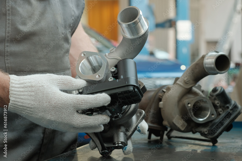 Car service. An auto mechanic replaces a faulty turbocharger. The ...
