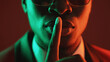 © golubovy - Shush gesture. Man secret. Confidential conspiracy. Green red neon light unrecognizable gentleman in suit glasses warning shh with finger on lips on dark.