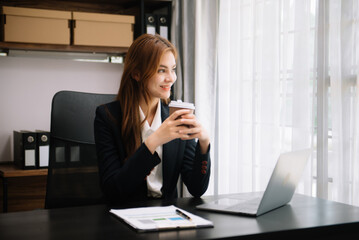 Young attractive Asian woman smiling thinking planning writing in notebook, tablet and laptop working from home at office .