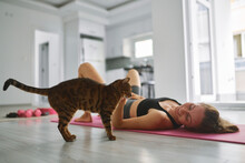 Happy Young Woman Stroking Cat And Exercising At Home