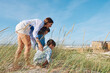 © Westend61 - Mother with children playing in grass at beach