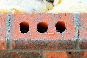 Insulating walls of new build houses by placing rock wool inside wall cavities as part of the energy-saving measures close-up. House insulated with mineral wool to reduce energy bill