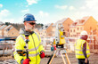 © Iryna - Surveyor builder site engineer with theodolite total station at construction site outdoors during surveying work
