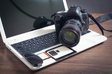 Modern DSLR camera and laptop computer.