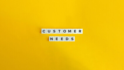 customer need term on block letter tiles on yellow background. minimal aesthetic.