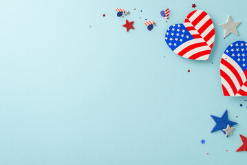 Wall Mural - National Day celebration. Top-down view of symbolic decorations: hearts showcasing USA flag design, glittery stars, confetti, against a pastel blue base with a vacant space for messages or advertising