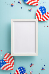 Wall Mural - Red, White, and Blue cheers. Overhead vertical perspective of emblematic decorations: American flag-inspired hearts, confetti on pastel blue backdrop with empty photo frame for text or picture