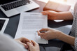 © rogerphoto - Business people sitting and discussing contract in office, closeup. Partners or lawyers working together at meeting. Teamwork and partnership