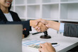 © NINENII - Lawyer shaking hands with client after discussing final contract agreement.