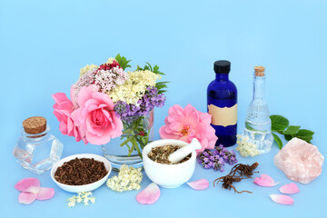 Wall Mural - Flowers and herbs used in natural alternative herbal medicine remedies. Medicinal sedative food ingredients with rose quartz crystal for healing. On blue background.