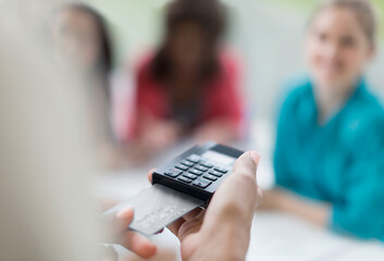 Poster - Close up waitress using credit card reader at cafe table