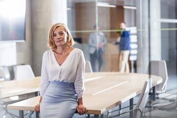 Wall Mural - Portrait confident businesswoman leaning on conference room table