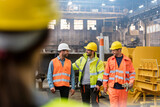 Fototapeta  - Steel workers walking and talking in factory