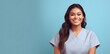 © Vladislava - Happy smiling beautiful young Latin female nurse in scrub with crossed arms on blue modern background studio portrait. Healthcare personnel, beauty care, physiotherapy, banner, AI Generated