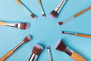 Sticker - Cosmetic makeup brush on blue background. Cosmetic product for make-up. Creative and beauty fashion concept. Fashion. Collection of cosmetic makeup brushes, top view, banner.Place for text. MOCAP.