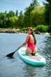 © zinkevych - Woman relaxing on sup surfboard, floating on water, recreational sports, paddle boarding.