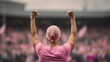 A woman raises her hands in front of a crowd in a campaign to fight breast cancer.