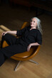 © ulza - lifestyle portrait senior woman  with gray hairrelaxes  in a black shirt and trousers rests in a chair.  copy space. greyhairdontcare.