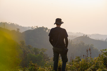 Canvas Print - silhouette hiker man relax on mountain with sunset background