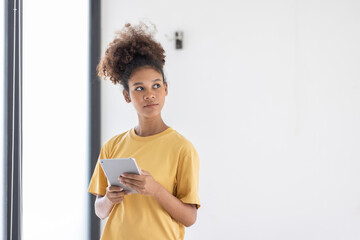 Wall Mural - Young pretty employee business african american woman work in office with tablet pc computer. Concept of surfing web with browse use pad gadget