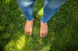 © mimagephotos - Female feet standing on green grass