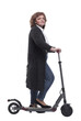© ASDF - side view. confident woman with an electric scooter looking at the camera