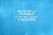 © cn0ra - Blue concrete wall with inspirational quotes - Believing in yourself is the first secret to success