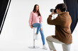 Stylish photoshoot. Male fashion photographer taking picture of young european woman in casual wear