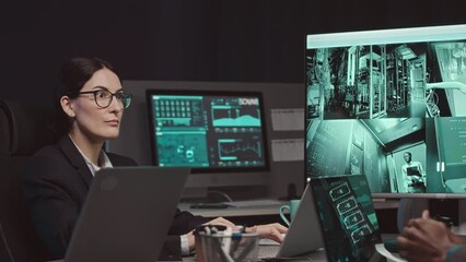 Wall Mural - diverse group of professional cybersecurity specialists watching cctv cameras in server room and mon