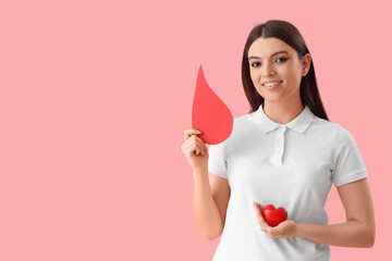Wall Mural - Female donor with paper blood drop and heart on pink background