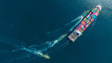 Aerial Top View Of Cargo Ship Carrying Container And Running With Tug Boat For Import Export Goods From Cargo Yard Port To Custom Ocean Concept Freight Shipping By Ship .