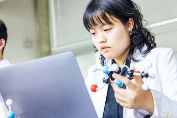 Poster - Female researcher looking at a molecular model. science student.