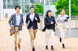 © metamorworks - Group of multinational people running on street. International business.