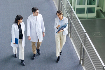 Poster - A multinational group having a conversation in the lobby.
People in white coats and sales staff. High angle view.