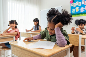 African American student doing exam in classroom at elementary school. 