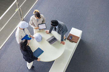 Poster - Group of multinational engineers and business people meeting in a building. International business. High angle view.
