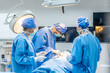 © Kawee - Professional doctors performing surgical operation in operating room.