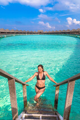 Canvas Print - Woman standing at the pool on Maldives