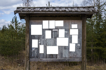 Old wooden bulletin board with empty white notes.