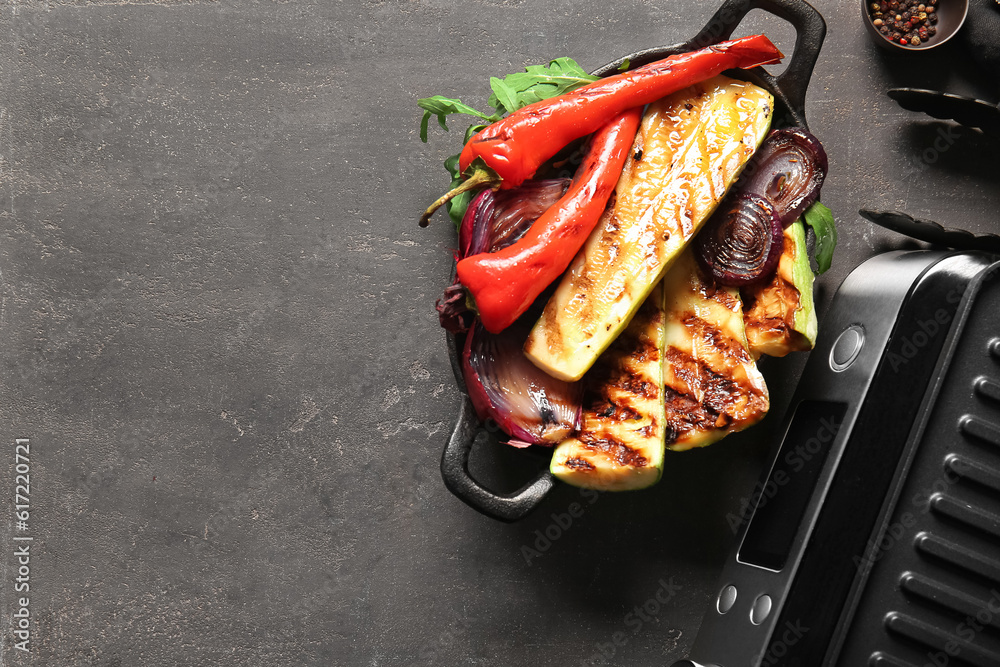 Baking dish with tasty grilled vegetables on dark background