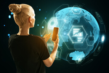 Poster - Back view of young blonde woman using mobile phone with digital business globe hologram on blurry background. Global technology, finance and web safety concept.