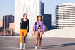 two friends walking along a city ready to run in a sunny day, concept of friendship and urban sport, copy space for text
