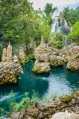 Canvas Print - Small waterfall and green pond in shady garden