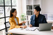 © Nuttapong punna - Two  Asian business  man and woman workers talking on the smartphone and using laptop Professionals in Teamwork  Finance, Marketing, and Success