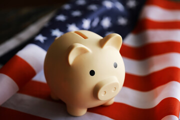 Closeup view of an American flag with a pink piggy bank for various financial concepts.