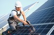 © Serhii - Worker installing solar panels outdoors.