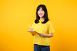 © Jirawatfoto - Experience the joy of education technology with portrait. A young Asian woman wearing a yellow t-shirt and denim jeans showcases a happy smile while using digital tablet. education technology concept.