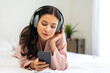 © Art_Photo - Portrait of smiling happy woman relax using digital smartphone.Young asian girl working or study,chatting social network and playing game online or social media,shopping online at home
