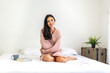 © Art_Photo - Portrait of smiling cheerful beautiful pretty woman clean fresh healthy white skin posing smile in pajamas pink clothes.Girl felling relax and enjoy time on the bed at home.asia beauty