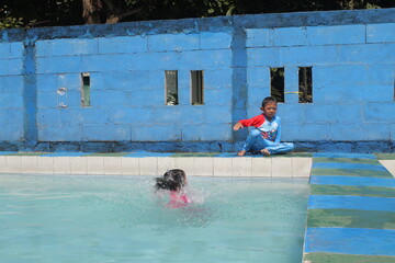 boys and girls practice swimming and playing in water
